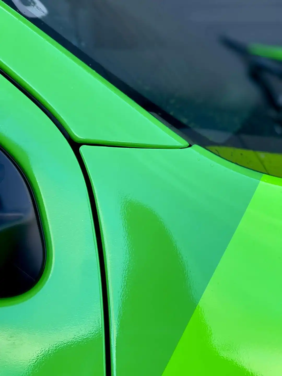 A picture of a car with neon vinyrl wrap done.