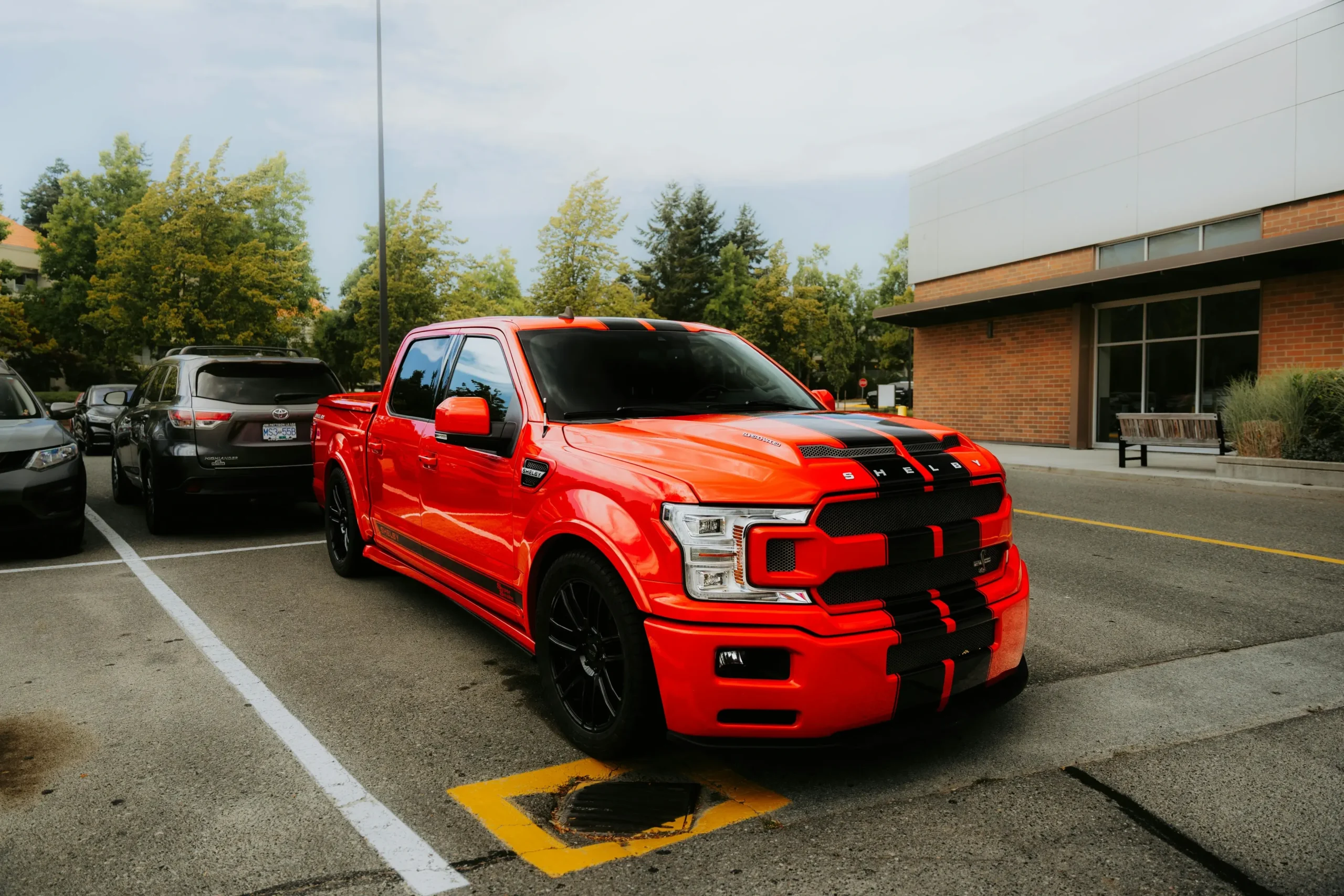 Bright orange truck with black custom racing decals designed and installed in San Antonio